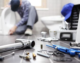 a Home Climates technician fixing a plumbing problem in a Harrisburg house