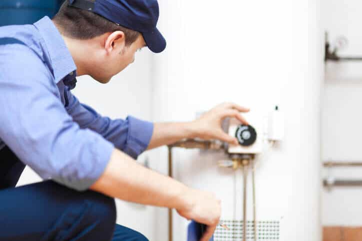 technician adjusting water heater thermostat