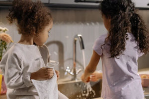Children washing up at the kitchen sink.