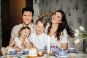 family gathers at table with spring flowers