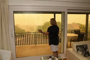 Woman looking at outside haze from wildfires