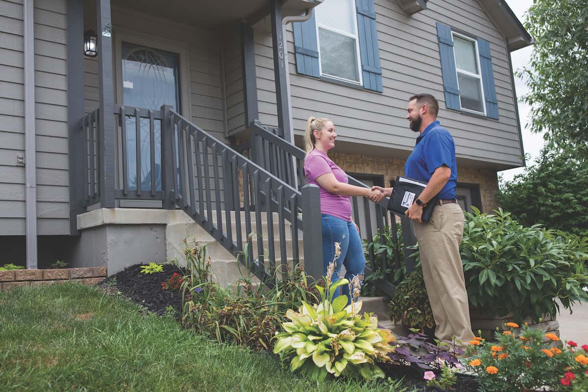 dealer-greeting-customer-on-porch Dealer Speaking with Customer