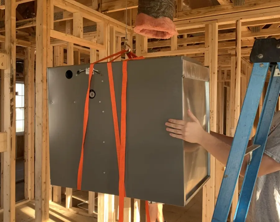 home-climates-ac-services a furnace being lowered into a house