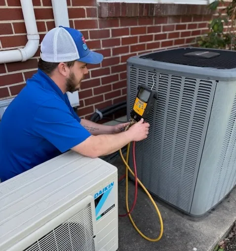 technician Home Climates HVAC technician servicing a system