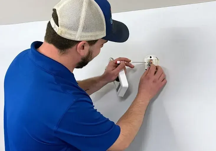 hvac technician working on thermostat