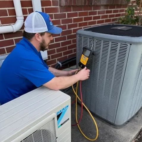 technician Home Climates HVAC technician servicing a system